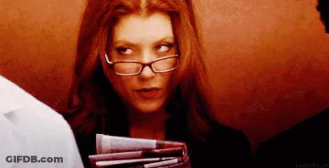A Woman Wearing Glasses Holds A Stack Of Papers GIF