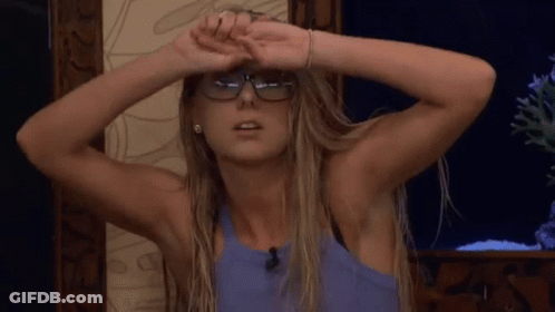 A Woman Wearing Glasses Is Covering Her Face With Her Hands And Making A Funny Face . GIF
