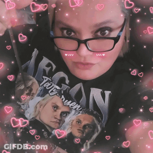 A Woman Wearing Glasses Is Holding A Book That Says Egon GIF