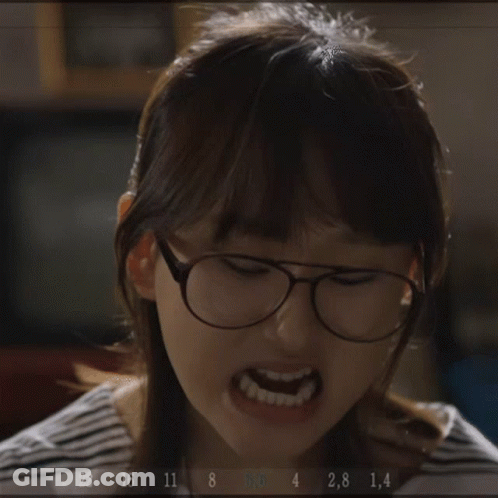 A Woman Wearing Glasses Is Making A Funny Face While Holding A Fork In Her Hand .. GIF