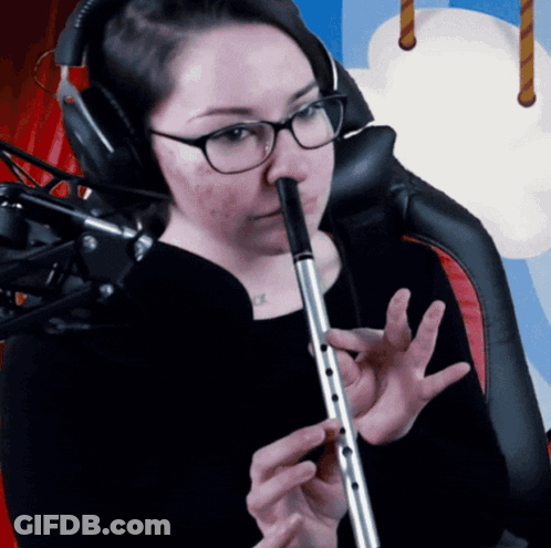 A Woman Wearing Glasses Is Playing A Flute GIF