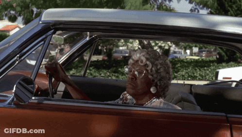 A Woman Wearing Glasses Is Sitting In A Car GIF