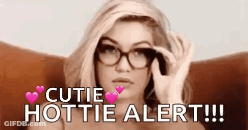A Woman Wearing Glasses Is Sitting In A Chair And Holding A Pair Of Glasses . GIF