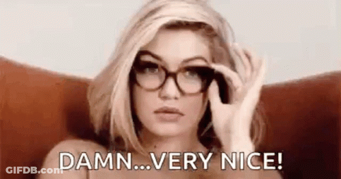 A Woman Wearing Glasses Is Sitting In A Chair And Saying `` Damn ... Very Nice '' . GIF