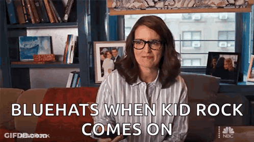 A Woman Wearing Glasses Is Sitting On A Couch With The Words `` Bluehats When Kid Rock Comes On '' GIF