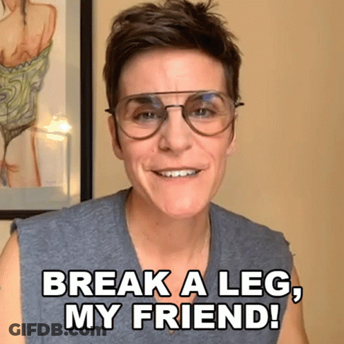 A Woman Wearing Glasses Is Smiling And Saying Break A Leg My Friend GIF