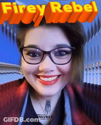 A Woman Wearing Glasses Is Smiling In Front Of A Poster That Says Firey Rebel GIF