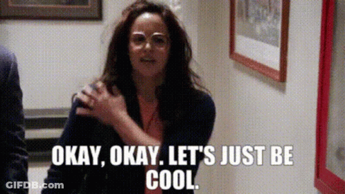 A Woman Wearing Glasses Is Standing In A Hallway And Says Okay Okay Let 'S Just Be Cool . GIF