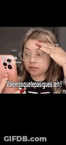 A Woman Wearing Glasses Is Taking A Selfie With Her Phone And Making A Funny Face . GIF
