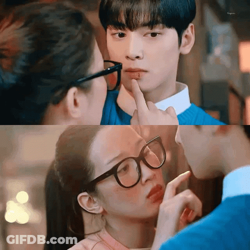 A Woman Wearing Glasses Is Touching A Man 'S Face With Her Finger . GIF