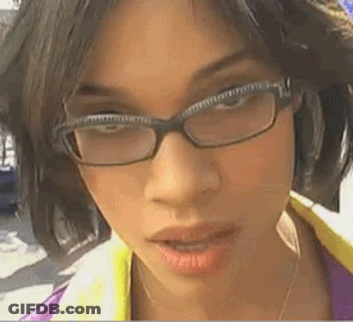 A Woman Wearing Glasses Looks At The Camera With Her Mouth Open GIF