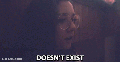 A Woman Wearing Glasses Says " Doesn 'T Exist " In A Dark Room GIF