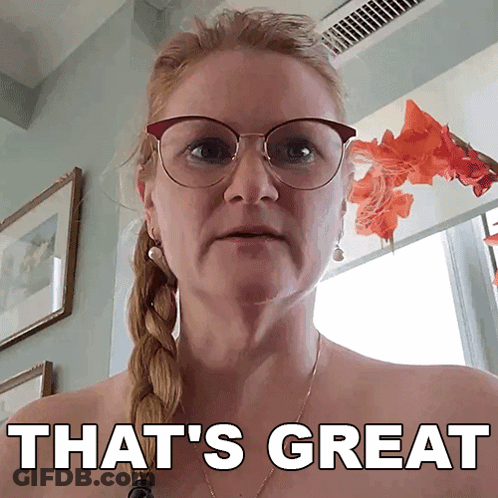 A Woman Wearing Glasses Says That 'S Great In Front Of A Window GIF