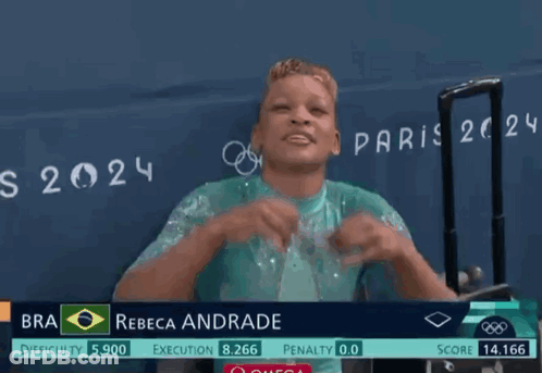 A Woman Wearing Glasses Stands In Front Of A Sign That Says " Rebeca Andrade " GIF