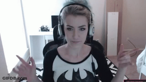 A Woman Wearing Headphones And A Batman T-Shirt Is Giving The Middle Finger GIF