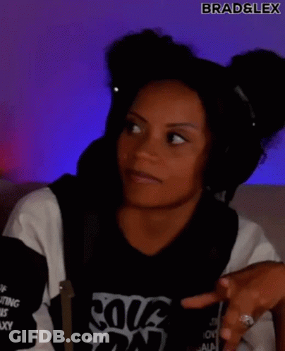 A Woman Wearing Headphones And A Black And White Shirt Is Making A Funny Face . GIF