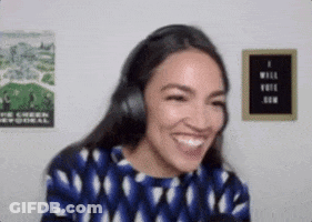 A Woman Wearing Headphones And A Blue Shirt Is Smiling And Laughing . GIF