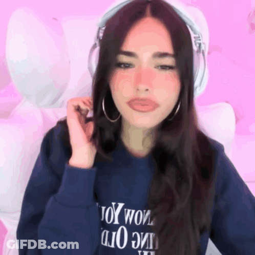 A Woman Wearing Headphones And A Blue Sweatshirt That Says Toy Wow GIF