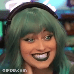 A Woman Wearing Headphones And A Green Wig Is Smiling GIF