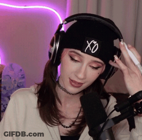 A Woman Wearing Headphones And A Hat With The Letter Xo On It GIF