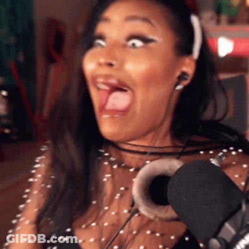 A Woman Wearing Headphones And A Headband Is Making A Funny Face In Front Of A Microphone GIF