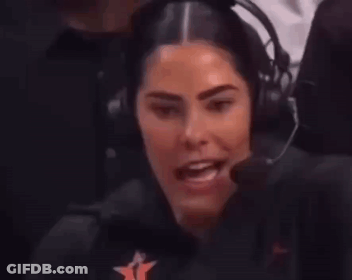 A Woman Wearing Headphones And A Microphone Is Sitting In Front Of A Microphone . GIF