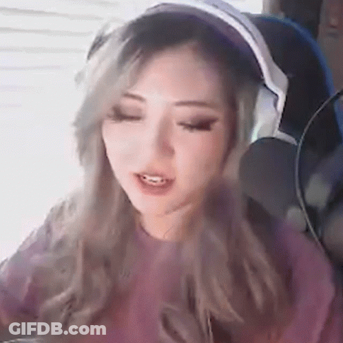 A Woman Wearing Headphones And A Pink Shirt GIF