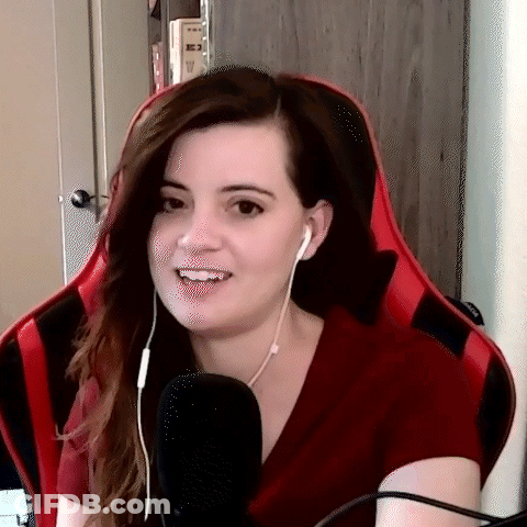 A Woman Wearing Headphones And A Red Shirt Is Sitting In A Red Chair . GIF