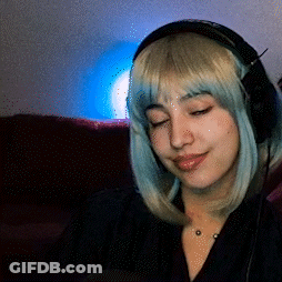 A Woman Wearing Headphones And A Wig Is Sitting On A Couch GIF