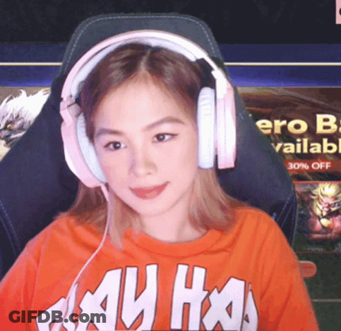 A Woman Wearing Headphones And An Orange Shirt That Says ' My Ho ' GIF