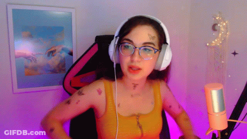 A Woman Wearing Headphones And Glasses Is Talking Into A Microphone GIF