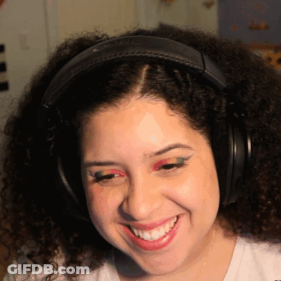 A Woman Wearing Headphones And Red Eye Shadow Smiles GIF