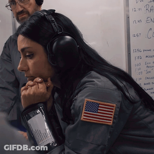 A Woman Wearing Headphones Has An American Flag Patch On Her Left Shoulder GIF