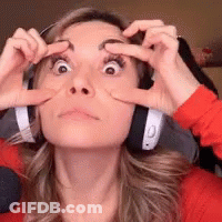 A Woman Wearing Headphones Has Her Hands On Her Eyes GIF