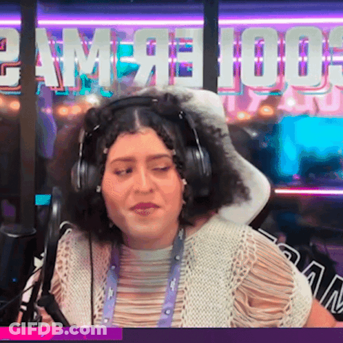 A Woman Wearing Headphones In Front Of A Sign That Says " Game 100 " GIF