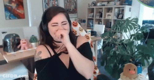 A Woman Wearing Headphones Is Covering Her Nose While Sitting In A Chair In A Living Room . GIF