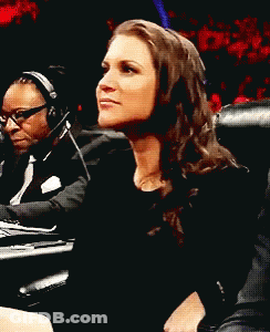 A Woman Wearing Headphones Is Laughing While Sitting Next To A Man GIF