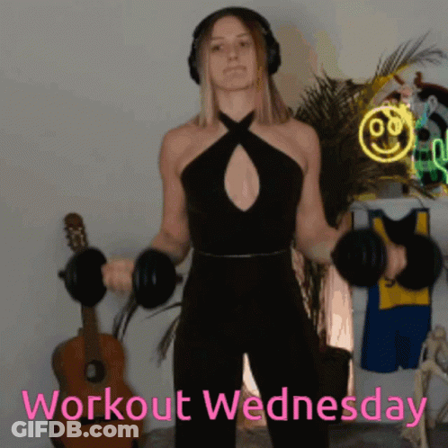 A Woman Wearing Headphones Is Lifting Dumbbells And The Words Workout Wednesday Are Visible Behind Her GIF