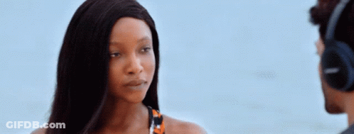 A Woman Wearing Headphones Is Looking At A Man GIF