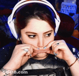 A Woman Wearing Headphones Is Making A Face GIF