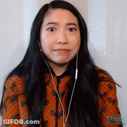 A Woman Wearing Headphones Is Making A Funny Face While Looking At The Camera . GIF