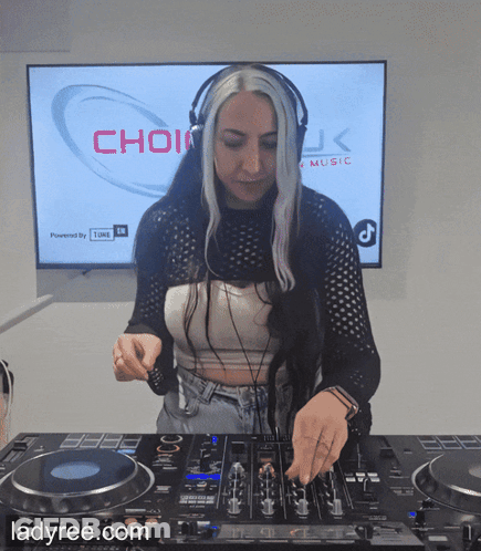 A Woman Wearing Headphones Is Playing Music In Front Of A Screen That Says Choir GIF