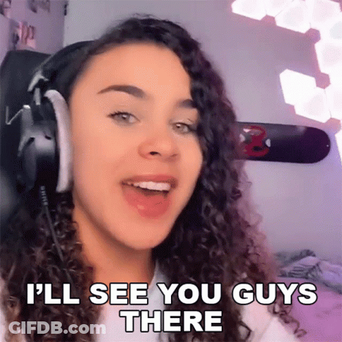 A Woman Wearing Headphones Is Saying " I 'Ll See You Guys There " GIF