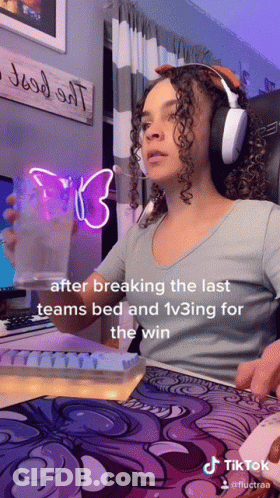 A Woman Wearing Headphones Is Sitting At A Desk In Front Of A Computer And A Sign That Says " Good All " GIF