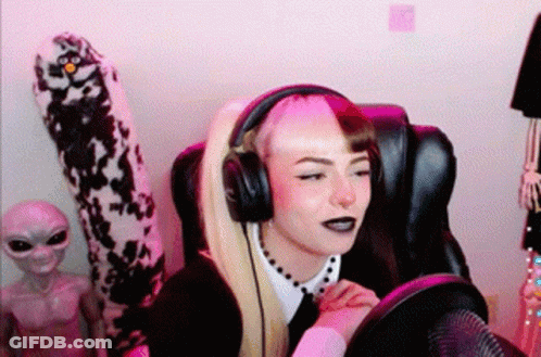 A Woman Wearing Headphones Is Sitting In A Chair . GIF