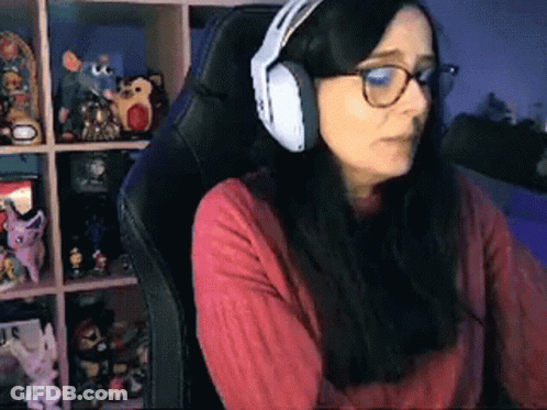 A Woman Wearing Headphones Is Sitting In A Chair . GIF
