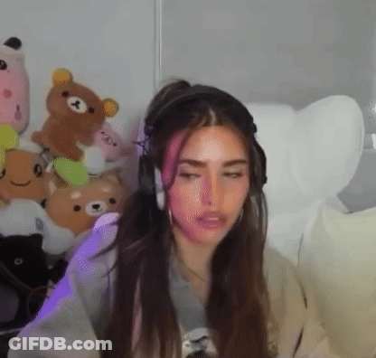 A Woman Wearing Headphones Is Sitting In A Chair In A Room With Stuffed Animals . GIF