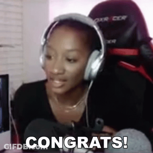 A Woman Wearing Headphones Is Sitting In Front Of A Computer And Says Congrats . GIF
