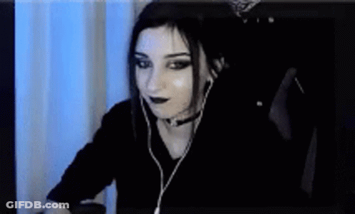 A Woman Wearing Headphones Is Sitting In Front Of A Computer . GIF