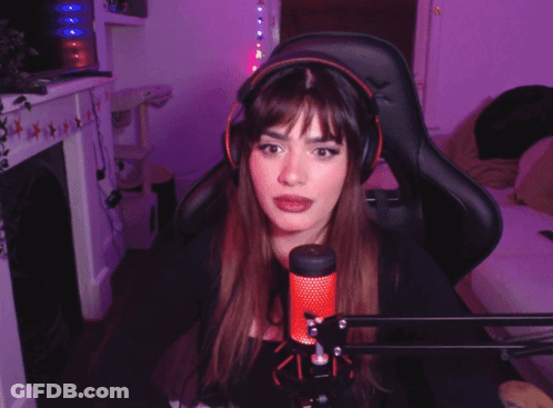 A Woman Wearing Headphones Is Sitting In Front Of A Microphone And Giving The Middle Finger GIF